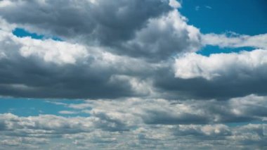 Beyaz kabarık bulutlar mavi gündüz vakti gökyüzünde yavaşça süzülür. Güzel gökyüzü hareket ediyor. Kar beyazı bulutlar yana doğru hareket ediyor..