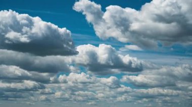 Beyaz kabarık bulutlar mavi gündüz vakti gökyüzünde yavaşça süzülür. Güzel gökyüzü hareket ediyor. Kar beyazı bulutlar yana doğru hareket ediyor..