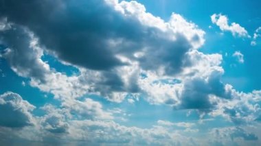 Beyaz kabarık bulutlar mavi gündüz vakti gökyüzünde yavaşça süzülür. Güzel gökyüzü hareket ediyor. Kar beyazı bulutlar yana doğru hareket ediyor..