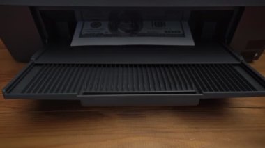 Sahte 100 dolarlık banknotun üzerinde parmak izi var. Sahte para, yasadışı eylemler. Yasadışı para basımı. A4 sayfasında Amerikan doları baskısı.