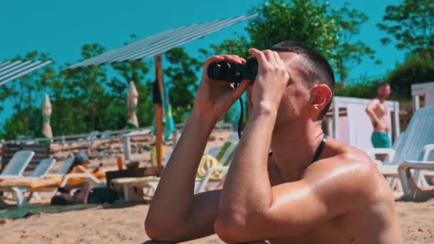 Muž Pláži Plavkách Sleduje Někoho Dalekohledem Plavčík Pláži Udržuje Vodě — Stock video