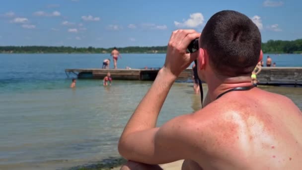 Facet Plaży Kąpielówkach Obserwuje Kogoś Przez Lornetkę Ratownik Plaży Utrzymuje — Wideo stockowe