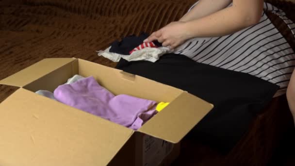 Gadis Muda Mengumpulkan Paket Dengan Hal Hal Dan Memeriksa Pakaian — Stok Video