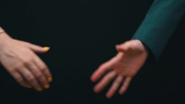 İki işadamı siyah bir arkaplanda el sıkışıyor, iyi anlaşma. Ceketli insanların el sıkışması. İş sözleşmesi. İki iş adamını selamlıyorum..