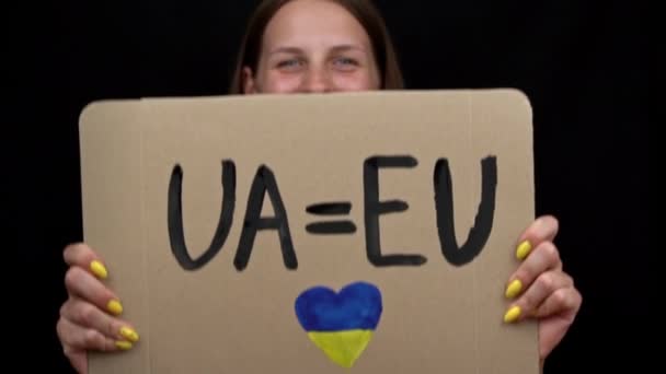 女孩举着海报 高兴地看到乌克兰成为欧洲联盟的候选国 乌克兰人现在受到欧洲的保护 没有战争 人民的暴力 女人的快乐 — 图库视频影像