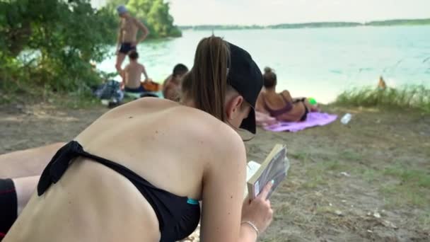 Young Girl Reading Book Beach Slow Swimsuit Woman Towel Sits — Stockvideo