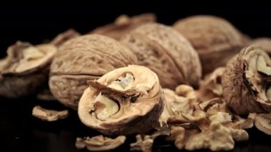 Kabukta bir sürü ceviz siyah arka planda dönüyor. Hayalar beyne iyi gelir. Yakın plan ceviz yığını..