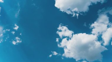Beyaz kabarık bulutlar mavi gündüz vakti gökyüzünde yavaşça süzülür. Güzel gökyüzü hareket ediyor. Kar beyazı bulutlar yana doğru hareket ediyor..