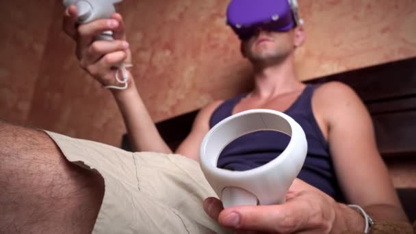 Man Virtual Reality Helmet Controls Controllers Young Man Home Sitting — 图库视频影像