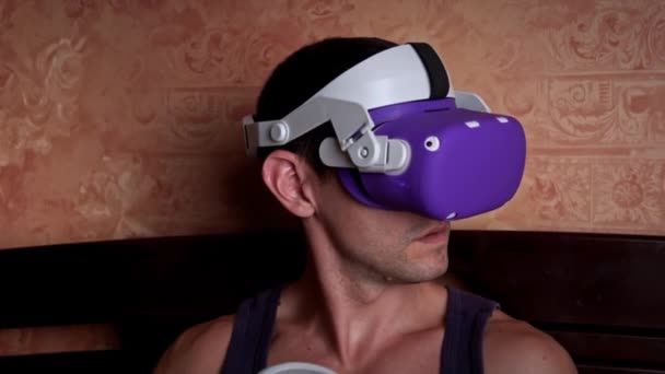 Man Virtual Reality Helmet Controls Controllers Young Man Home Sitting — kuvapankkivideo