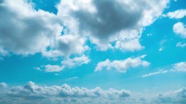Beyaz kabarık bulutlar mavi gündüz vakti gökyüzünde yavaşça süzülür. Güzel gökyüzü hareket ediyor. Kar beyazı bulutlar yana doğru hareket ediyor..