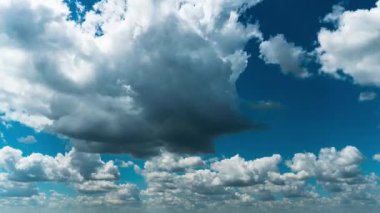 Beyaz kabarık bulutlar mavi gündüz vakti gökyüzünde yavaşça süzülür. Güzel gökyüzü hareket ediyor. Kar beyazı bulutlar yana doğru hareket ediyor..