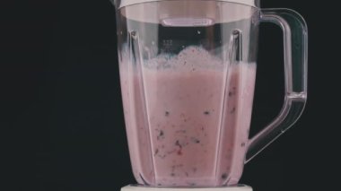 Blender böğürtlen ve sütü yavaş bir milkshake 'e çevirir. Büyük bir blender kasesinde çilek, frenk üzümü ve süt. Taze meyve milkshake 'e dönüşür..