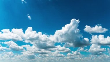 Beyaz kabarık bulutlar mavi gündüz vakti gökyüzünde yavaşça süzülür. Güzel gökyüzü hareket ediyor. Kar beyazı bulutlar yana doğru hareket ediyor..