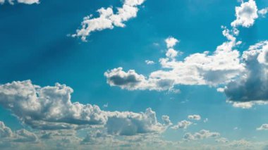 Beyaz kabarık bulutlar mavi gündüz vakti gökyüzünde yavaşça süzülür. Güzel gökyüzü hareket ediyor. Kar beyazı bulutlar yana doğru hareket ediyor..