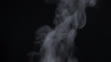White steam on a black background. White natural rising steam from food or hot drink isolated on black background.