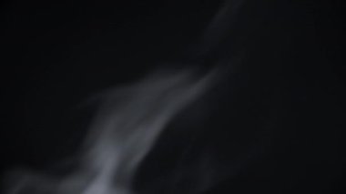 White steam on a black background. White natural rising steam from food or hot drink isolated on black background.