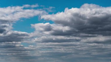 Beyaz kabarık bulutlar mavi gündüz vakti gökyüzünde yavaşça süzülür. Güzel gökyüzü hareket ediyor. Kar beyazı bulutlar yana doğru hareket ediyor..