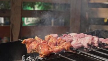 Meat barbecue is fried on skewers and in the grill in nature. Cooking delicious barbecue in nature. Delicious food on a metal skewer in a barbecue. Picnic time. Street eatery. Food Festival. Pork on
