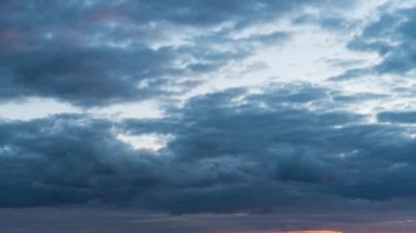 Zaman ayarlı gri yağmurlu bulutlar bulutlu bir günde karanlık gökyüzünde yüzerler. Bulutlu gökyüzü ve kasvetli bulutlar. Yağmurlu havada büyülü dramatik gökyüzü. Uğursuz bulutlar gökyüzünde yavaşça sürükleniyor, yağmuru tehdit ediyor..