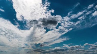 Beyaz kabarık bulutlar mavi gündüz vakti gökyüzünde yavaşça süzülür. Güzel gökyüzü hareket ediyor. Kar beyazı bulutlar yana doğru hareket ediyor..