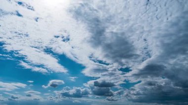 Beyaz kabarık bulutlar mavi gündüz vakti gökyüzünde yavaşça süzülür. Güzel gökyüzü hareket ediyor. Kar beyazı bulutlar yana doğru hareket ediyor..