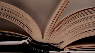 Beyaz kitaptaki sayfaları yavaş çekimde kapatıyoruz. Kitap okumak, istihbarat. Sayfalar peş peşe akıyor. Kadınların elleri kitap sayfalarını karıştırır..
