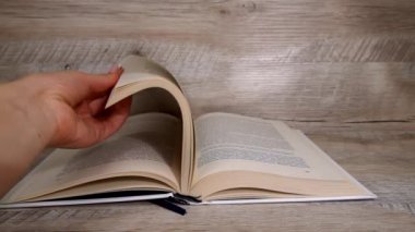 Beyaz kitaptaki sayfaları yavaş çekimde kapatıyoruz. Kitap okumak, istihbarat. Sayfalar peş peşe akıyor. Kadınların elleri kitap sayfalarını karıştırır..