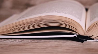 Beyaz kitaptaki sayfaları yavaş çekimde kapatıyoruz. Kitap okumak, istihbarat. Sayfalar peş peşe akıyor. Kadınların elleri kitap sayfalarını karıştırır..