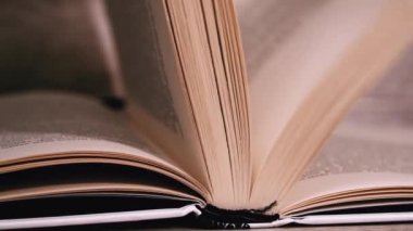 Beyaz kitaptaki sayfaları yavaş çekimde kapatıyoruz. Kitap okumak, istihbarat. Sayfalar peş peşe akıyor. Kadınların elleri kitap sayfalarını karıştırır..