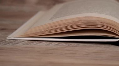 Beyaz kitaptaki sayfaları yavaş çekimde kapatıyoruz. Kitap okumak, istihbarat. Sayfalar peş peşe akıyor. Kadınların elleri kitap sayfalarını karıştırır..