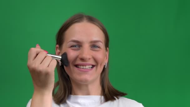Όμορφη Κοπέλα Ζωγραφίζει Πρόσωπό Της Ένα Πινέλο Πράσινο Φόντο Νεαρή — Αρχείο Βίντεο