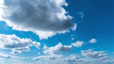 Beyaz kabarık bulutlar mavi gündüz vakti gökyüzünde yavaşça süzülür. Güzel gökyüzü hareket ediyor. Kar beyazı bulutlar yana doğru hareket ediyor..