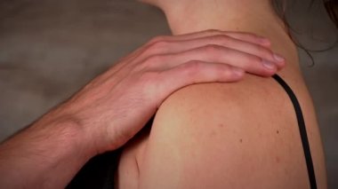 Bir adamın parmakları siyah sutyenini bir kadında çözer. Kızın arkasını yakın çekim ve sütyenin kopçasını. Erkek ve kadın erotik ve seksi giyiniyor.