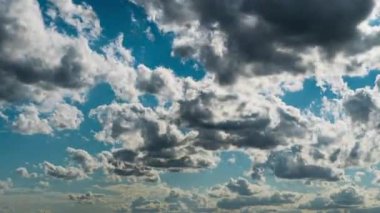 Beyaz kabarık bulutlar mavi gündüz vakti gökyüzünde yavaşça süzülür. Güzel gökyüzü hareket ediyor. Kar beyazı bulutlar yana doğru hareket ediyor..