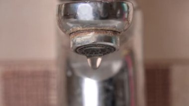 Banyodaki musluktan akan suyun yakın çekimi. Musluktan gelen su akışı. Şehir borularında suyun saflığı.