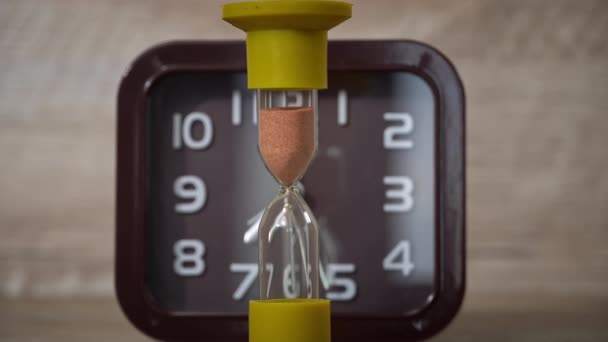 Timeglassklokka Renner Mot Den Vanlige Mekaniske Bakgrunnsvakten Sanden Øser Ned – stockvideo