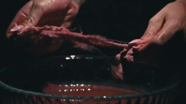 Kanla kaplı kadın elleri ve bandajlar karanlıkta ellerini yıkıyor. Kanlı pislik. Korkunç bir kanama. Kırmızı kan damlaları yüzeye düşer. Kanlı korkuluklar..