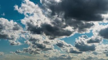 Beyaz kabarık bulutlar mavi gündüz vakti gökyüzünde yavaşça süzülür. Güzel gökyüzü hareket ediyor. Kar beyazı bulutlar yana doğru hareket ediyor..