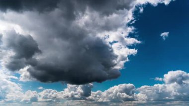 White fluffy clouds slowly float through the blue daytime sky timelapse. Beautiful skies are moving. Airy snow-white clouds move to the side.