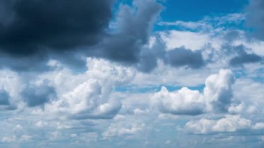 White fluffy clouds slowly float through the blue daytime sky timelapse. Beautiful skies are moving. Airy snow-white clouds move to the side.