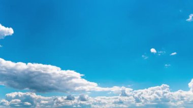White fluffy clouds slowly float through the blue daytime sky timelapse. Beautiful skies are moving. Airy snow-white clouds move to the side.