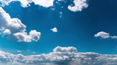 Beyaz kabarık bulutlar mavi gündüz vakti gökyüzünde yavaşça süzülür. Güzel gökyüzü hareket ediyor. Kar beyazı bulutlar yana doğru hareket ediyor..