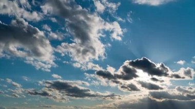 Beyaz kabarık bulutlar mavi gündüz vakti gökyüzünde yavaşça süzülür. Güzel gökyüzü hareket ediyor. Kar beyazı bulutlar yana doğru hareket ediyor..