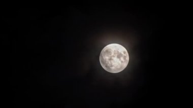 Güzel ay, bulutların arasından gece gökyüzünü aydınlatır. Geceleyin ayın önünden bulutlar geçer. Geceleri dolunay ve gerçek zamanlı bulutlar. Gizemli peri sahnesi.