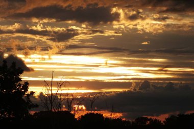 Letonya, Riga. Riga 'nın Bolderaja bölgesinin doğal parkında fırtına bulutlarına karşı gün batımı.