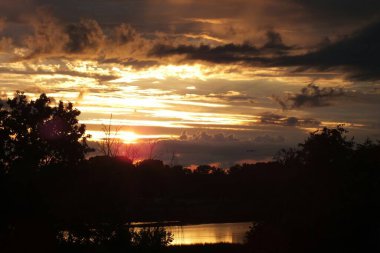 Letonya, Riga. Riga 'nın Bolderaja bölgesinin doğal parkında fırtına bulutlarına karşı gün batımı.