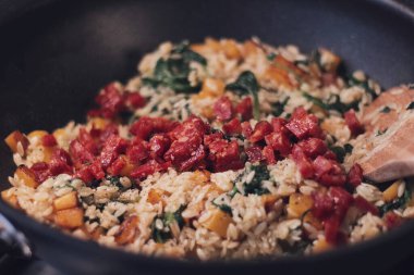 Warm orzo meal in a pan with pumpkin
