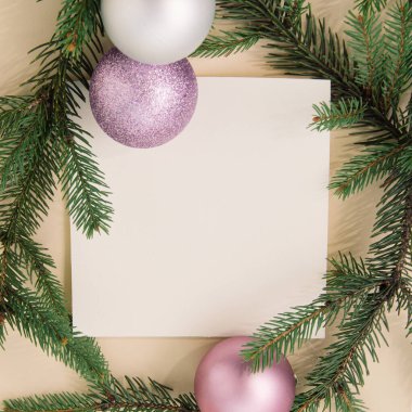 Şampanya rengi arka planında parlak takılar, dallar ve kağıt kartlardan oluşan Noel sahnesi. Yaratıcı yeni yıl görüntüsü. Düz yatıyordu.