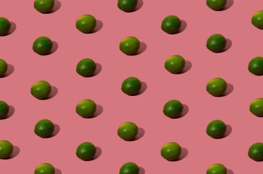 Organic green lime pattern on a pastel pink background. Hipster flat lay concept.